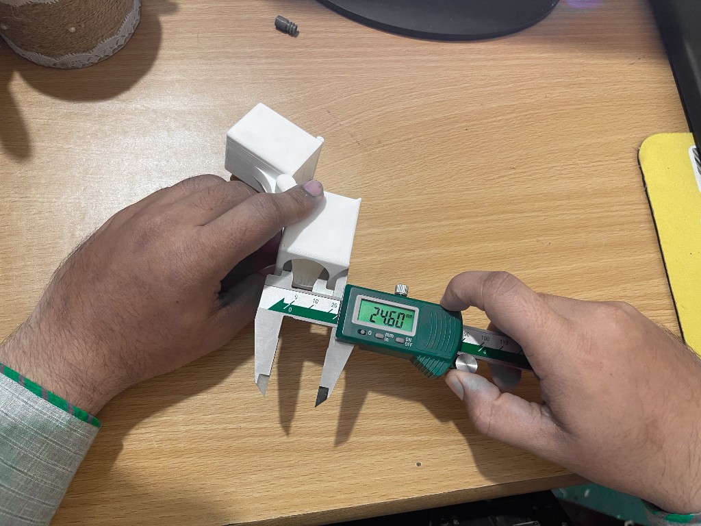 Engineer measuring a 3D printed functional prototype with digital calipers